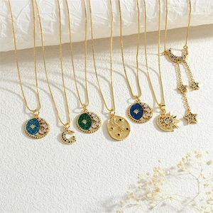 Macro detail of gold celestial necklaces with zircon-studded sun and moon pendants
