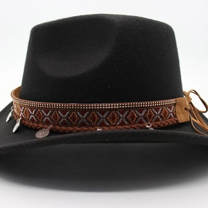 Detail of ethnic embroidery band and metal coin charms on black felt cowboy hat