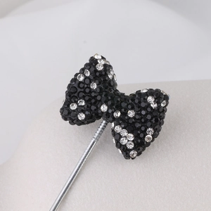 Macro shot of black beaded bow brooch with sparkling silver rhinestones and metal pin