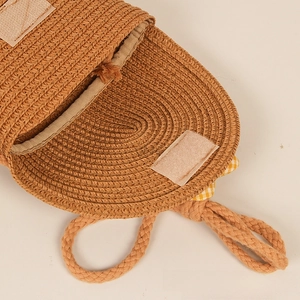 Detail view of handmade straw bag showing woven texture and cream velcro closure