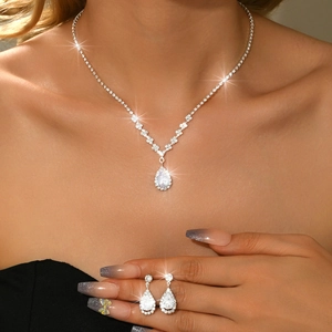 Macro detail of teardrop zircon jewelry set with silver necklace and stud earrings