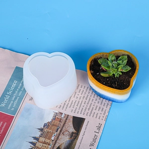 Vista macro dello stampo in silicone a cuore con dettaglio del vaso in resina colorata