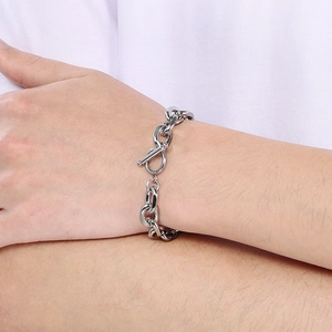 Close-up of a silver stainless steel chunky Cuban link chain bracelet with an OT clasp