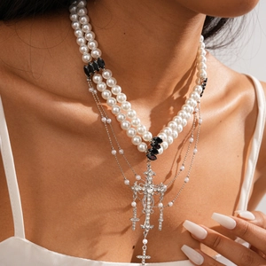 Close-up of double-layer vintage gothic necklace with pearls and rhinestone cross pendant