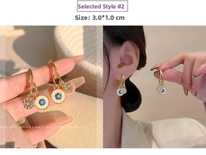 Detail of gold tassel earrings with blue floral enamel and crystal charms, 3.0x1.0cm