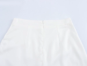 Detail of the back waist on white floral skirt featuring an invisible zipper closure