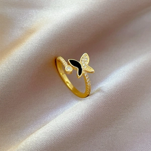 Macro shot of 18K gold butterfly ring with black enamel and white zircon details