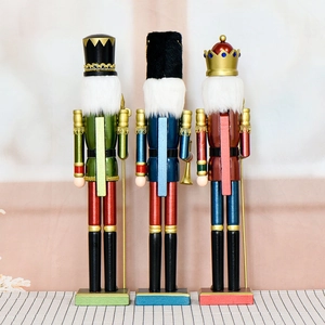 Three 55cm pearlescent wooden nutcracker soldiers standing on a checkered tablecloth