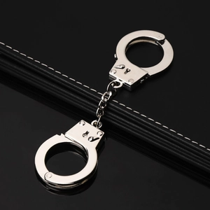 Polished silver metal miniature handcuffs keychain shown from a 45-degree angle
