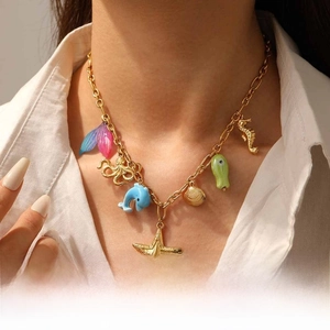 Close-up of a gold chain necklace featuring colorful marine pendants and charms