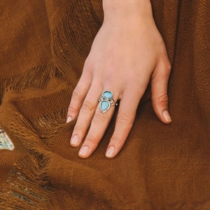 Dettaglio di un anello vintage in argento con pietre azzurre sulla mano di una modella