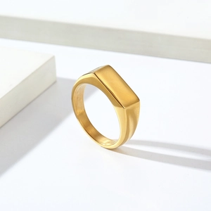 Minimalist gold signet ring with a polished rectangular face on a clean white background