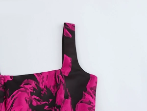 Detail of black floral jacquard dress showing wide shoulder straps and textured fabric
