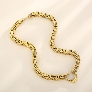 Detail of golden stainless steel Byzantine chain with a hollow heart pendant