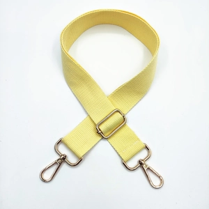 Detail of yellow canvas strap with adjustable golden metal buckle and swivel hooks