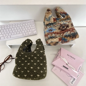 Détail de sacs à main en peluche avec texture polaire et doublure à carreaux