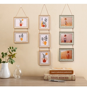 Hanging wooden photo frame set with rustic hemp rope strings on a warm textured wall