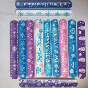 Variety of winter themed slap bracelets with snowflake designs and holiday phrases