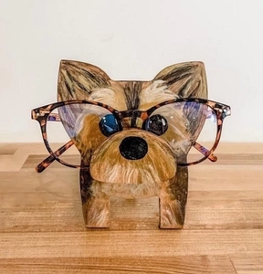 Detail of hand-painted wooden Yorkshire Terrier eyeglass holder on a wood table