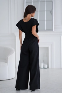 Detail view of the elegant back zipper and waist design on a black wide-leg jumpsuit