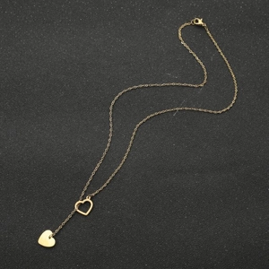 Detail of gold ECG stethoscope heart necklace with polished pendant on black texture