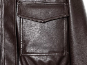 Macro shot of faux leather jacket pocket with detailed stitching and deep brown texture