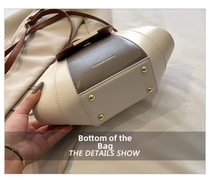 Macro detail of the contrast leather handbag bottom with four protective gold metal studs