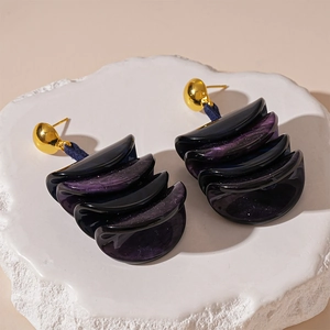 Irregular deep purple resin geometric earrings with gold-tone studs on a stone base