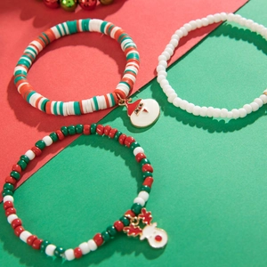 Close-up of Christmas charm bracelets with Santa and reindeer pendants on red and green beads