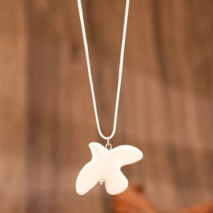 Collier pendentif oiseau blanc minimaliste avec finition lisse sur un cordon blanc fin