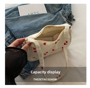 Spacious white corduroy shoulder bag with cherry patterns showing storage capacity