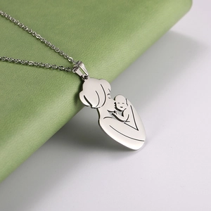 Close-up of mother and baby silhouette pendant on a silver stainless steel necklace