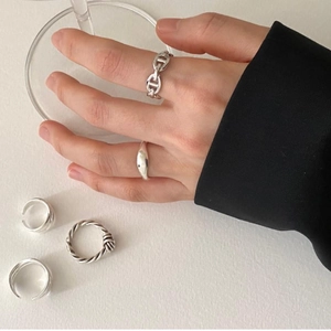 Detail of 925 sterling silver ring set featuring anchor chain and minimalist twist designs