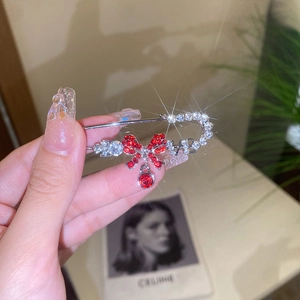 Elegant silver safety pin brooch with red rhinestone bow and crystal tassel details