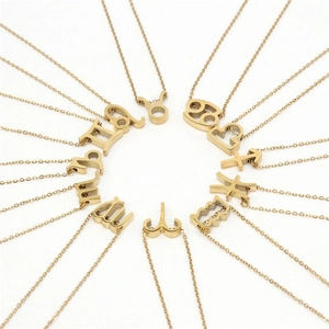 Colliers avec pendentifs zodiaque en acier plaqué or présentés sur un fond blanc pur