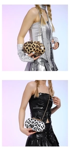 Detail of leopard print clutch featuring a gold bow clasp and elegant metal chain strap