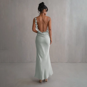 Détail d'une robe en satin bleu clair avec fleur en 3D sur le dos et l'épaule de la robe