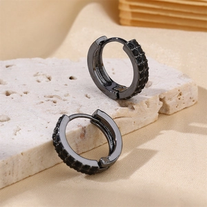 Macro shot of black circular stud earrings with paved black zircon on stone base