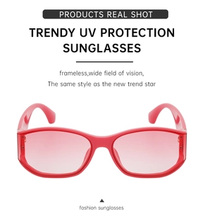 Detail view of bold red curved sunglasses with gradient pink lenses and UV protection