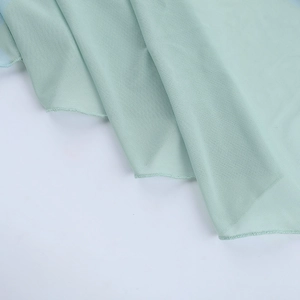 Détail du tissu en maille vert menthe montrant la texture fine et la qualité respirante