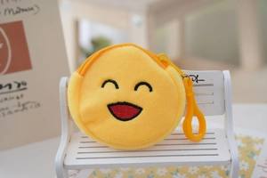 Detail of yellow round plush coin purse with smiley face embroidery and plastic hook