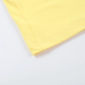Close-up detail of the yellow knitted dress showing neat hemline and high-quality stitching