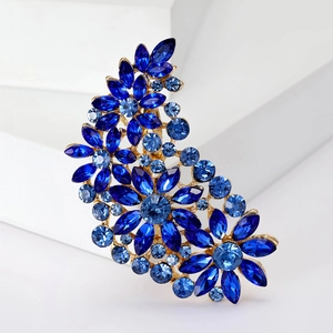 Detailed close-up of a floral brooch with blue rhinestones and a gold-colored alloy base