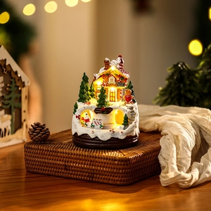 Detailed view of a lighted musical Christmas resin house with a gingerbread man figurine.