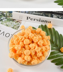 Détail de pop-corn orange en PVC dans un bol en verre transparent pour décor intérieur