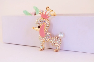 Macro detail of golden metal puppy keychain with rainbow rhinestones and pink crown