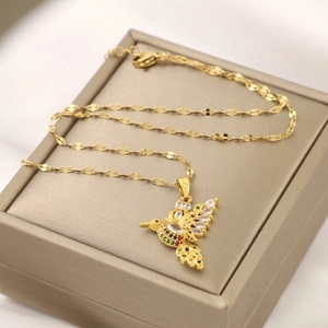 Golden hummingbird necklace with colorful zircon stones on a champagne gift box