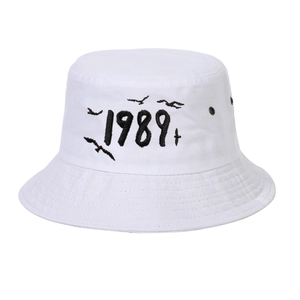 Detailed embroidery of 1989 text and flying bird on a white cotton canvas bucket hat