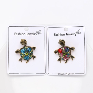 Detailed view of turtle brooches with colorful rhinestones on a display card