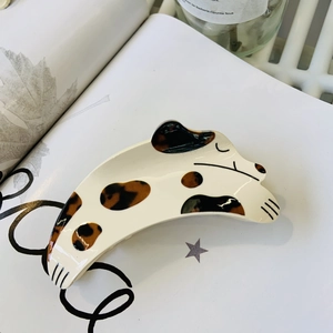 Pince à cheveux chien dalmatien en acrylique avec strass sur un fond de livre